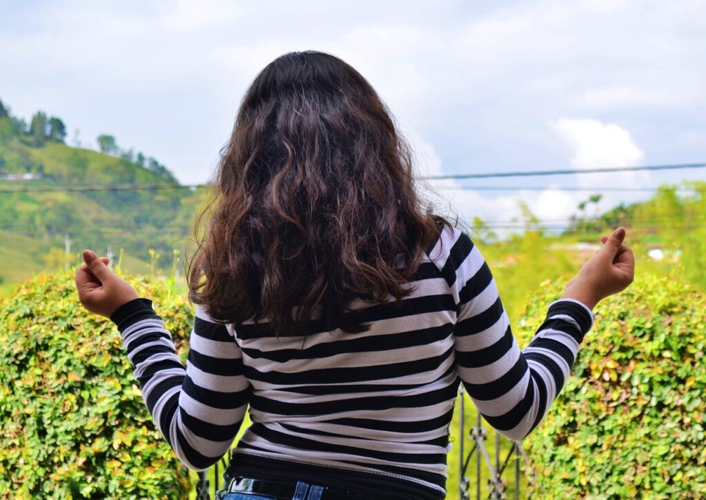 woman looks into the distance and shrugs